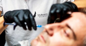 injektion med muskelavslappnande medel under en rynkbehandling på en manlig patient